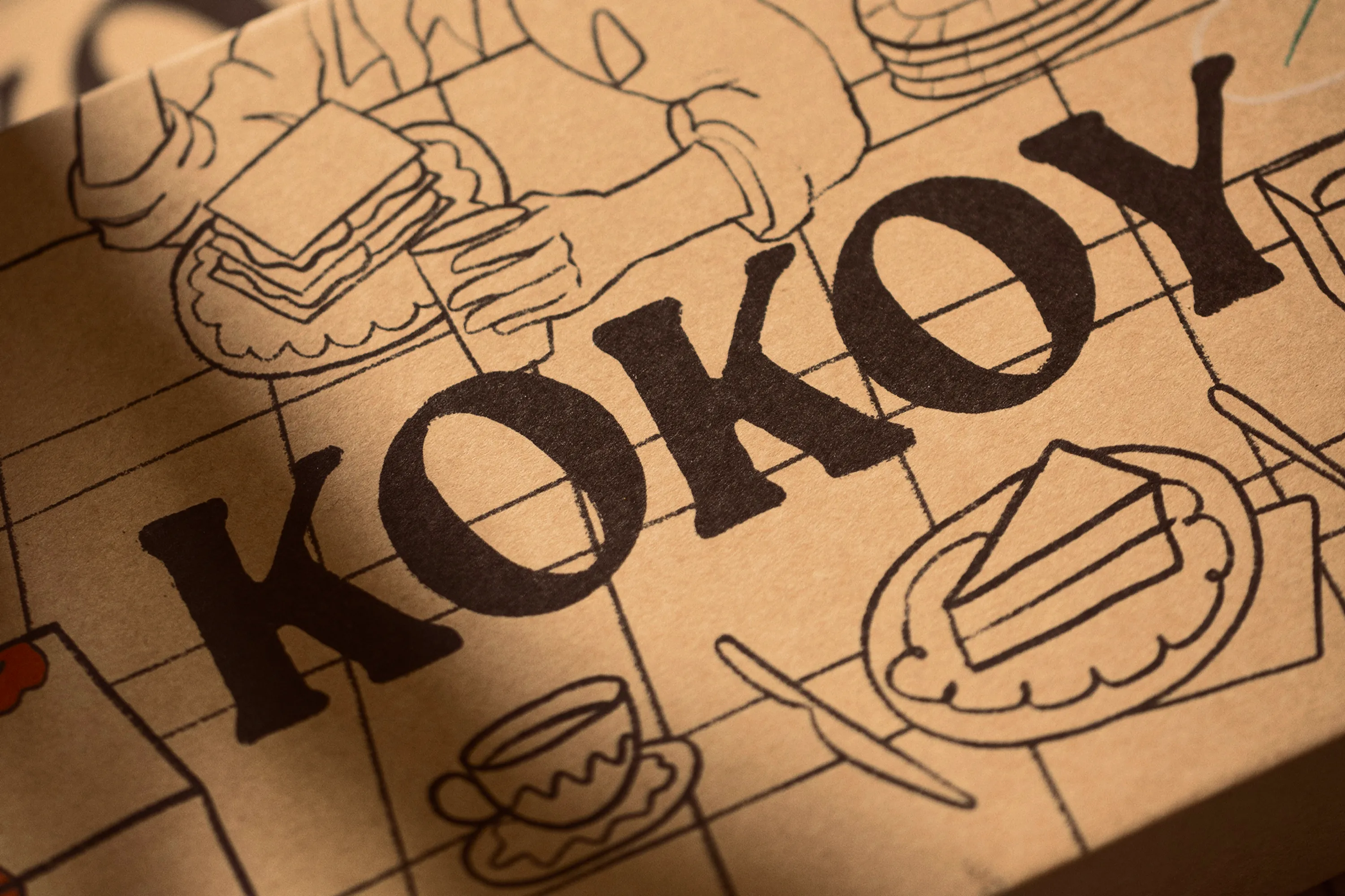 Kokoy illustrated packaging paper with a large wordmark.