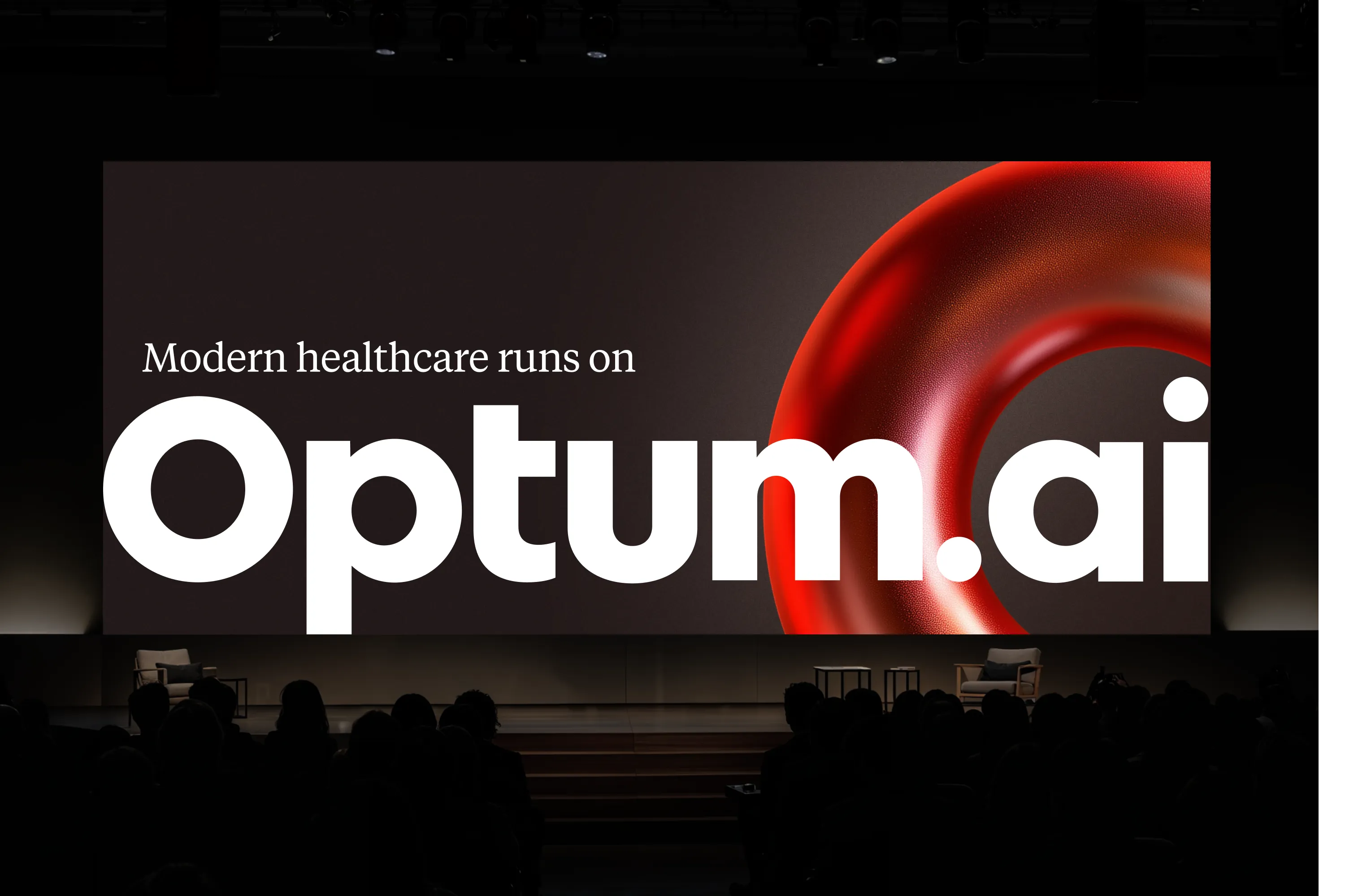 Optum.ai stage presentation with Modern healthcare runs on Optum.ai and a red sculptural ring.